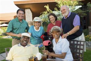 Group of adults smiling around golf equipment and dressed to play.